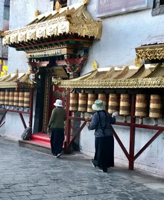 Tibetan women spinning prayer wheels along the Barkhor kora - Lhasa, Tibet